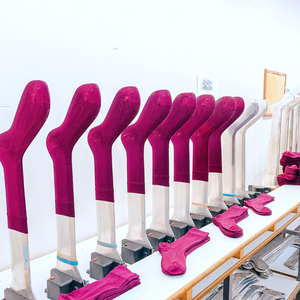 A shelf displaying a row of iron legs in pink and white hues, adding a touch of charm and elegance to the overall decor.