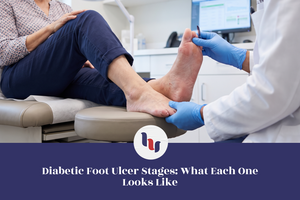 Healthcare professional examining a patient's bare foot in a medical clinic