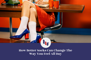 Person seated at a desk wearing white crew socks with blue high-heeled shoes, legs crossed in a retro office setting with warm colors and vintage details