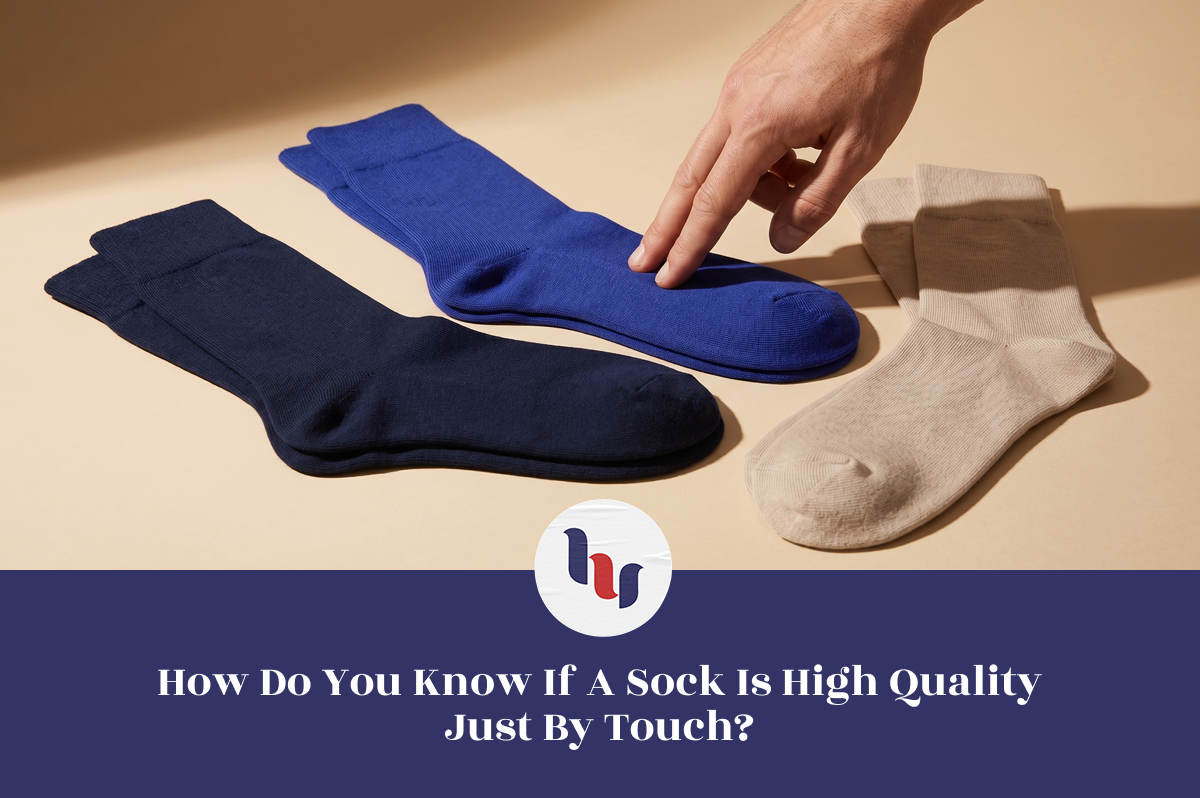 Three pairs of socks (blue, black, beige) on a beige background with a hand touching the blue sock.