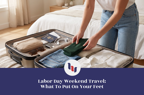Woman packing green socks and travel essentials into an open suitcase for Labor Day weekend.