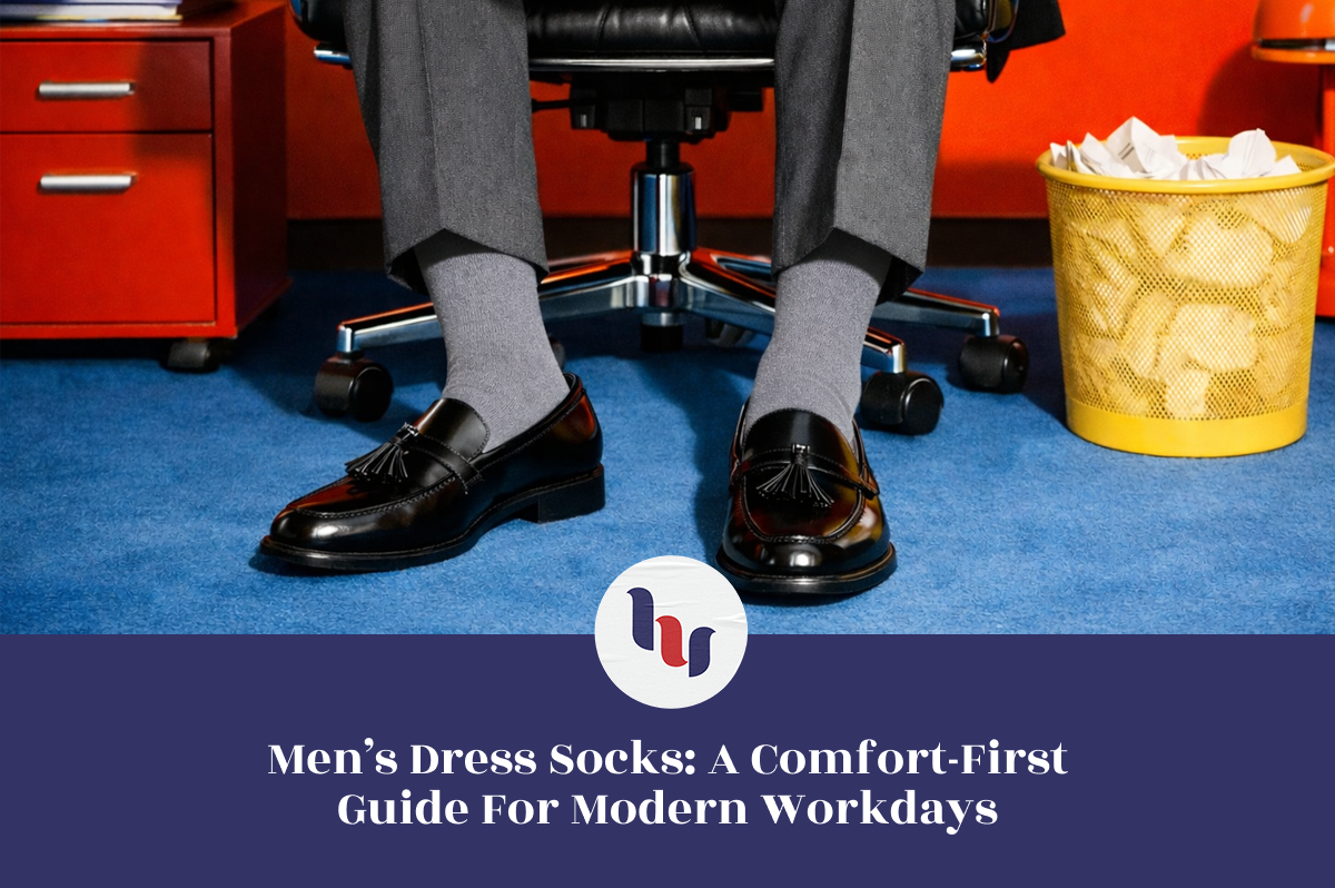 Person wearing black dress shoes and gray dress socks sitting on a chair with office furniture in the background.