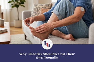 Older woman with a glucose sensor attempting to trim her toenails while seated at home.