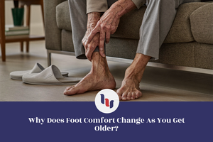 Older adult holding an aching foot at home, illustrating how foot comfort changes with age.