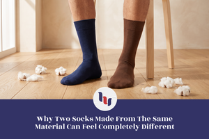 Two plain crew socks made from similar materials displayed with cotton fibers.