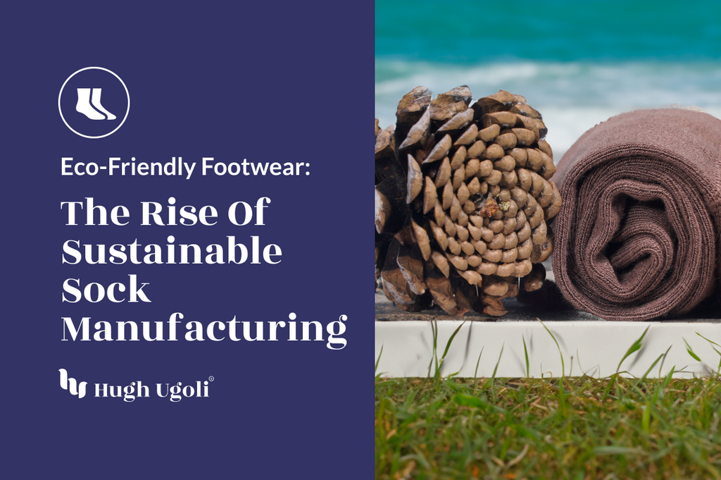 A rolled-up pair of brown Hugh Ugoli socks rests next to a pine cone, symbolizing the brand's commitment to eco-friendly and sustainable sock manufacturing, against a backdrop of lush green grass and clear blue water.