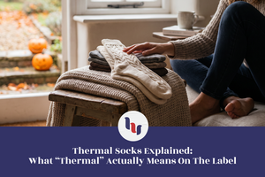 Woman selecting thick knit socks from a stack of cozy winter clothing at home