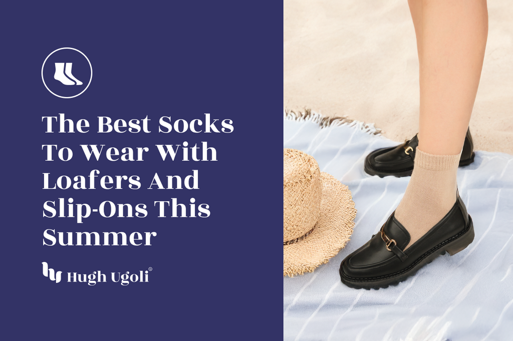 Close-up of a person wearing beige Hugh Ugoli socks with black loafers, standing on a light blue beach towel next to a straw hat on sandy ground — the perfect summer pairing for loafers and slip-ons.