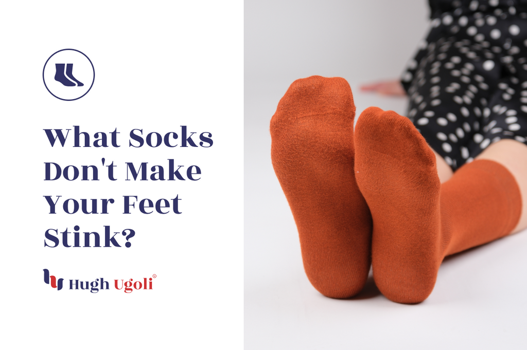 The image displays the question "What Socks Don't Make Your Feet Stink?" along with a person seated wearing bright orange socks, representing a product offering from Hugh Ugoli's sock collection that presumably addresses concerns of foot odor.