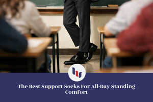 Person standing in a classroom with students seated at desks, blurred background