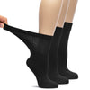 This image depicts three pairs of black Bamboo Diabetic Crew Socks, each pair with a woman's foot wearing them.
