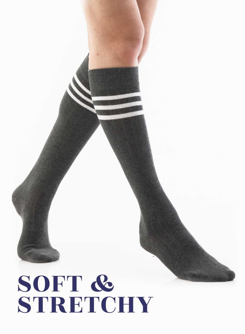 Gray knee-high socks with white stripes worn by a person on a white background, with text 'SOFT & STRETCHY'.
