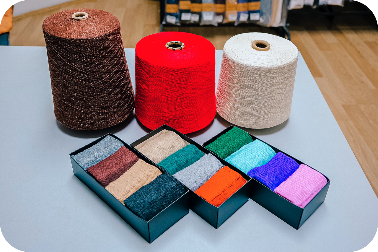 Assorted yarn supplies including spools and a box. Collection of colorful yarn spools and a storage box. Yarn crafting essentials - spools and a container.