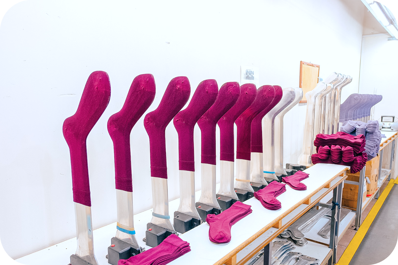 A shelf displaying a row of iron legs in pink and white hues, adding a touch of charm and elegance to the overall decor.