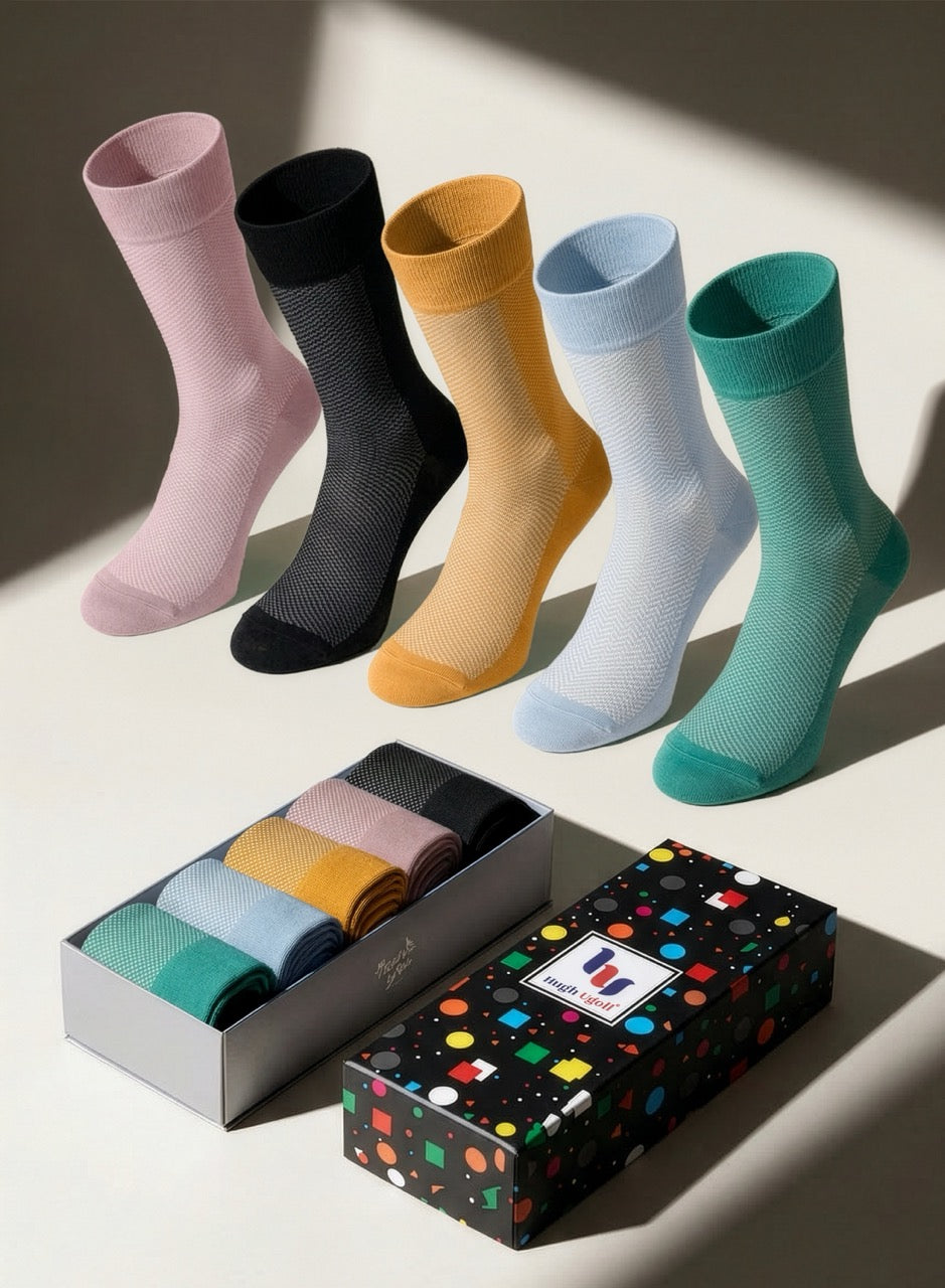 Set of colorful socks with a patterned box on a light background