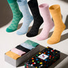 Set of colorful socks with a box featuring a brand logo on a light background