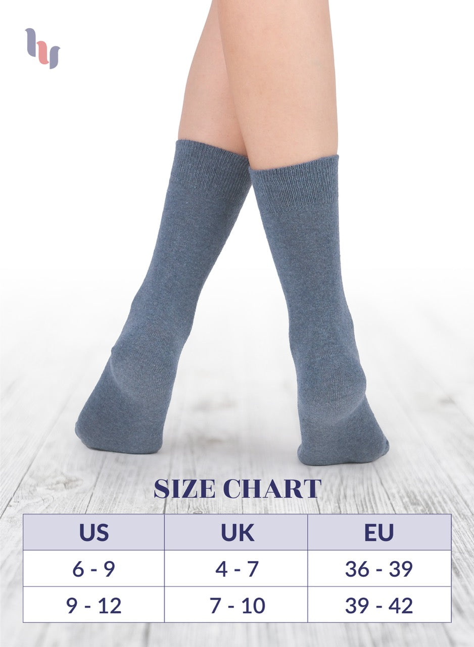 Indigo knee-high socks on a light wooden floor with a size chart below.