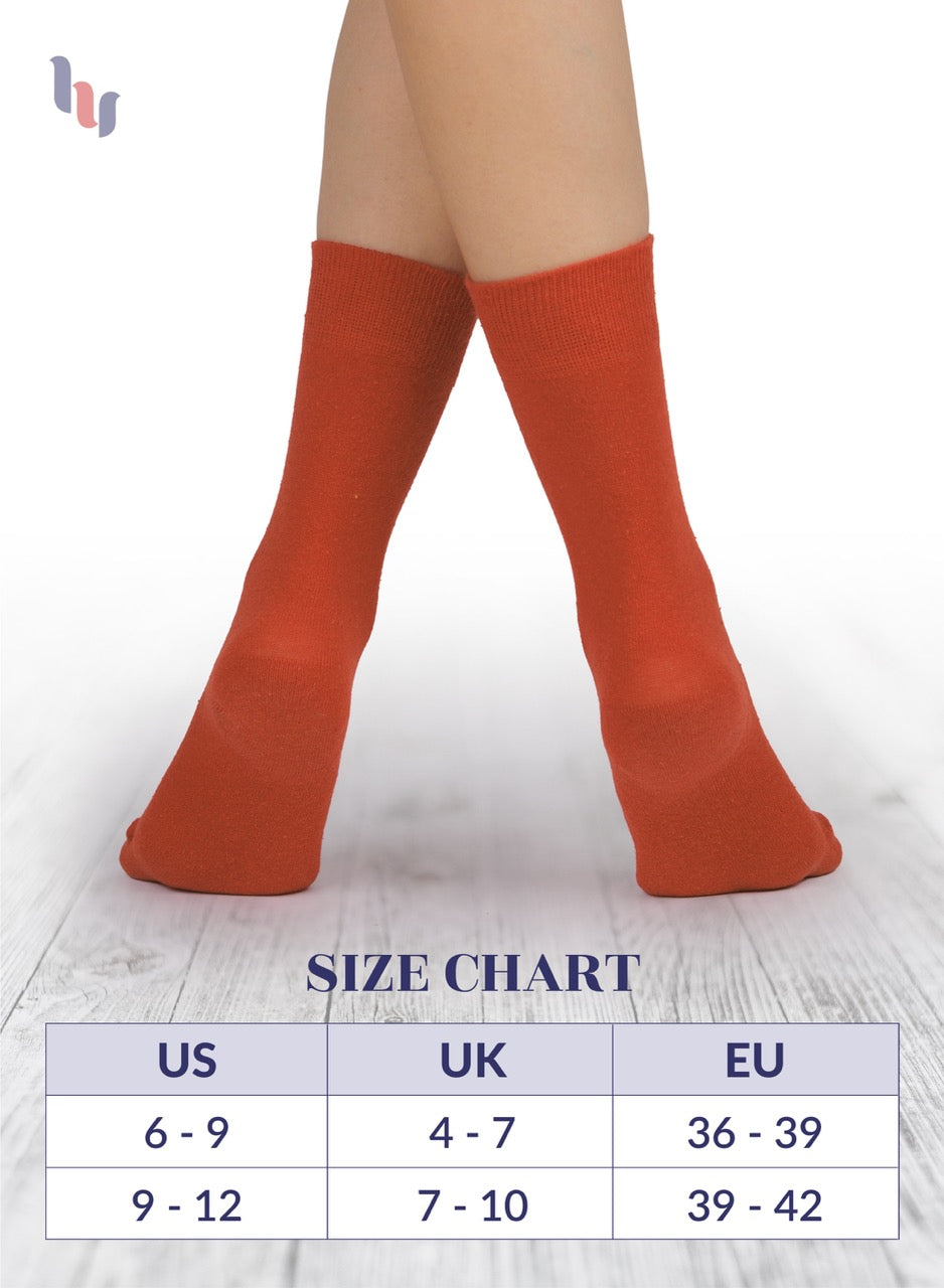 Red socks on feet with size chart below on a light background