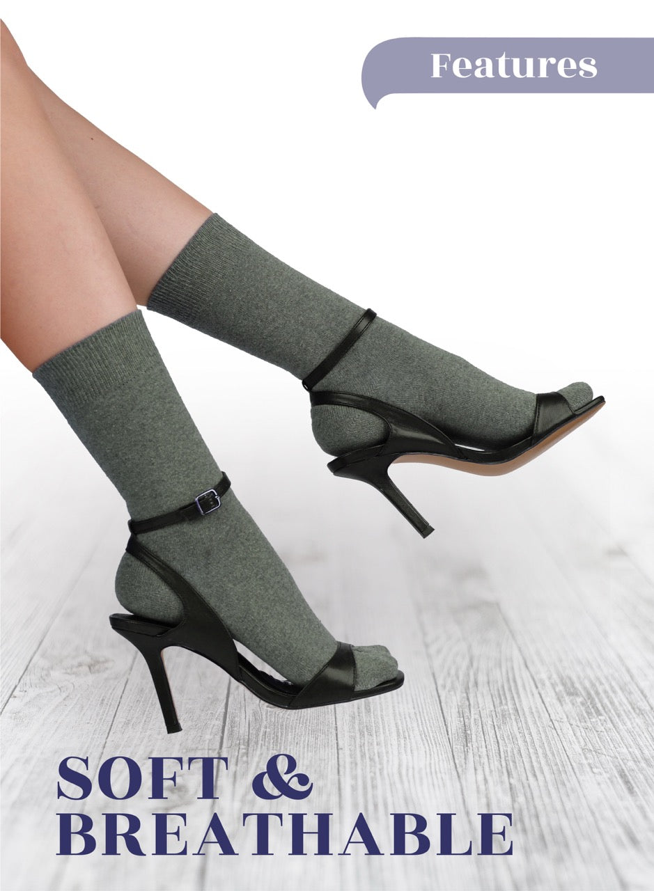 High-heeled shoes with gray socks on a light wooden floor, featuring text 'Soft & Breathable'.