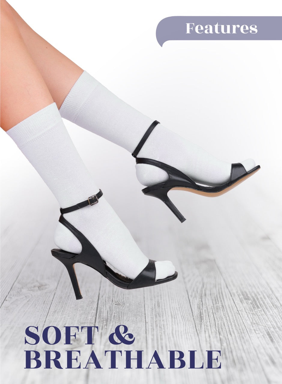 Black high-heeled shoes with white socks on a light wooden floor.