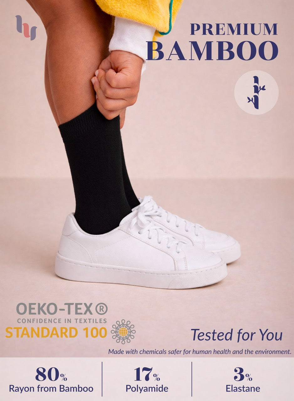 Person wearing black socks and white sneakers with text about premium bamboo and OEKO-TEX certification.