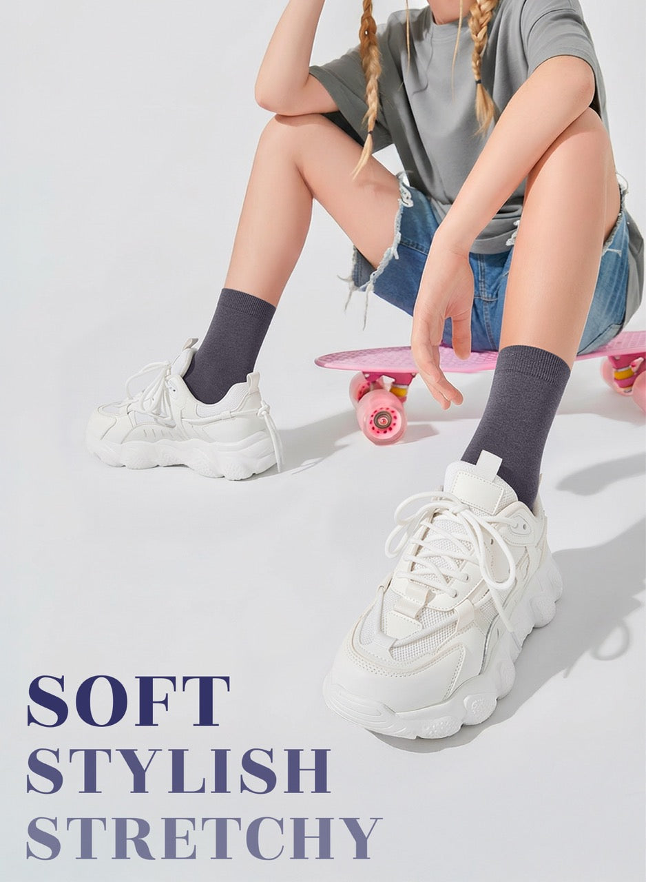 Person wearing white sneakers with text 'SOFT STYLISH STRETCHY' on a light background