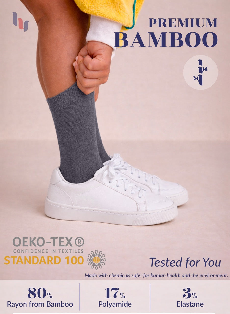 Person wearing gray socks and white sneakers with text about premium bamboo socks and OEKO-TEX certification.