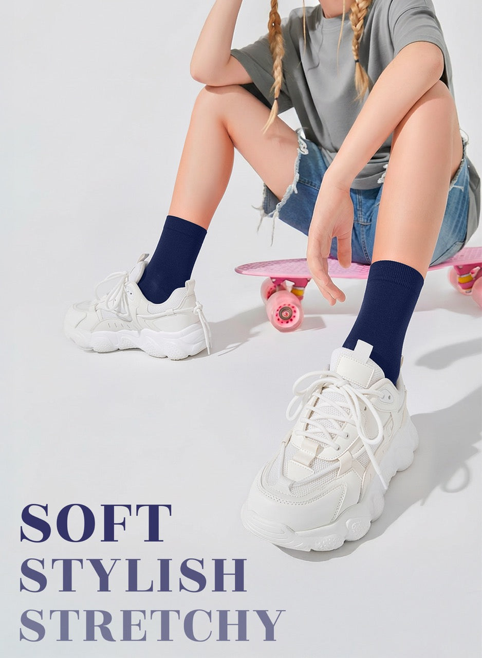 Person wearing white sneakers and dark socks sitting on a pink skateboard with text 'SOFT STYLISH STRETCHY' on a light gray background.