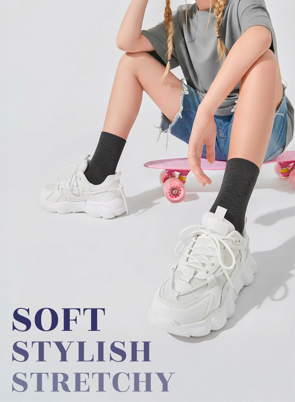 Person wearing white sneakers with text 'SOFT STYLISH STRETCHY' on a light background