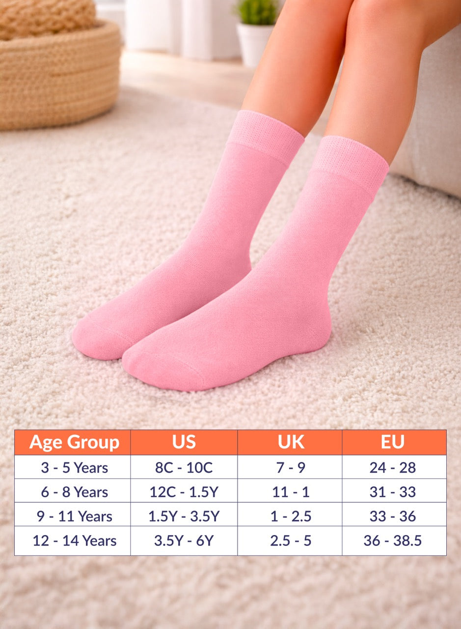 Pink socks on feet with a size chart for children's shoes below.