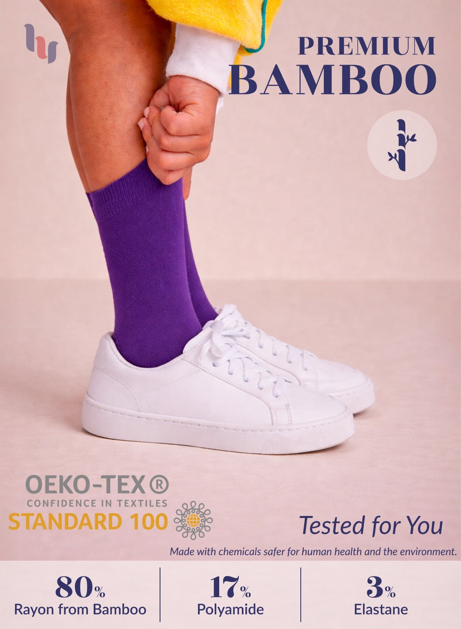 Person wearing purple bamboo socks with white sneakers on a light background