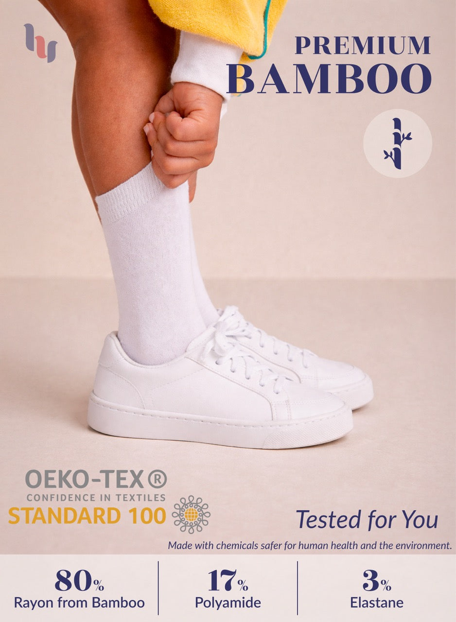 Person wearing white sneakers and socks with text about premium bamboo and OEKO-TEX certification on a beige background.