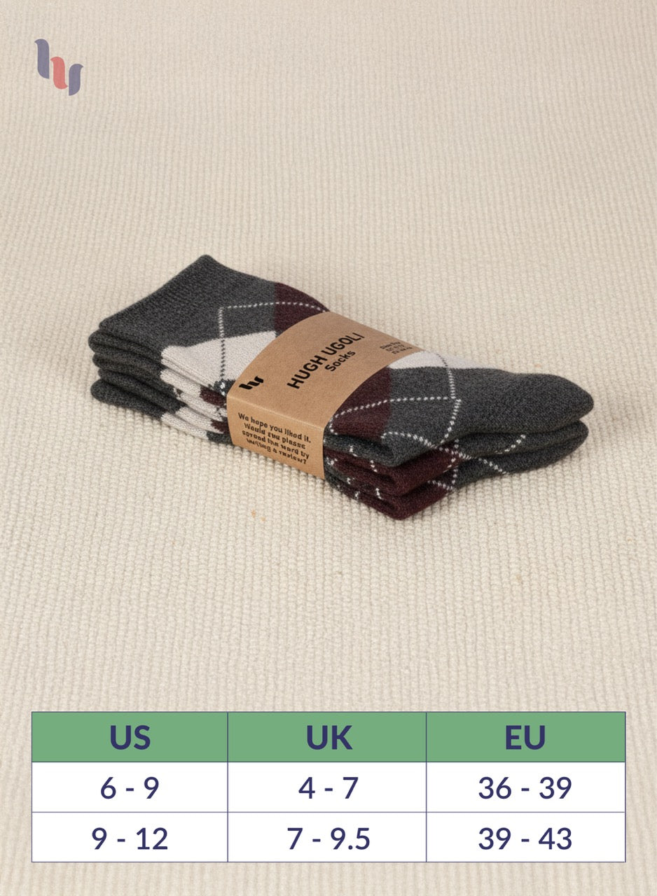 Pack of dark army green socks with a label on a beige fabric background