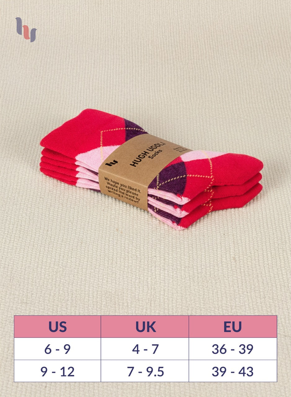 Stack of red and pink checkered socks with a size chart on a beige background