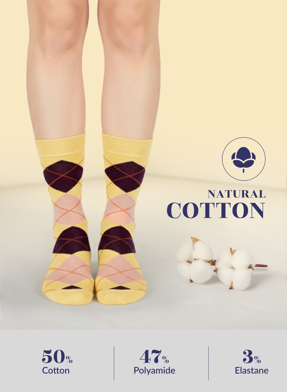 Colorful patterned yellow socks with natural cotton label on a light background