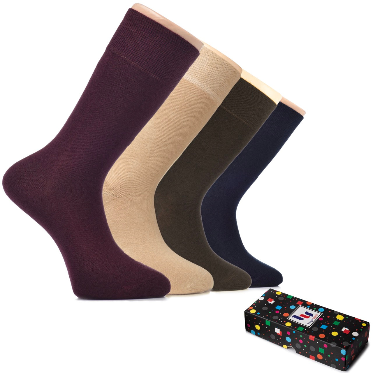 Four pairs of socks in burgundy, beige, brown, navy blue socks with a polka dot box on a white background