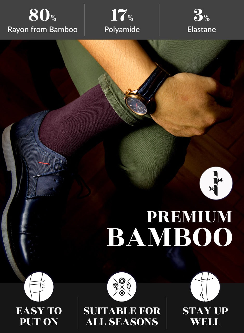 Person wearing dark shoes, Burgundy socks, and a green sock with a watch on a wooden floor. Text on the image indicates material composition and features of bamboo socks.