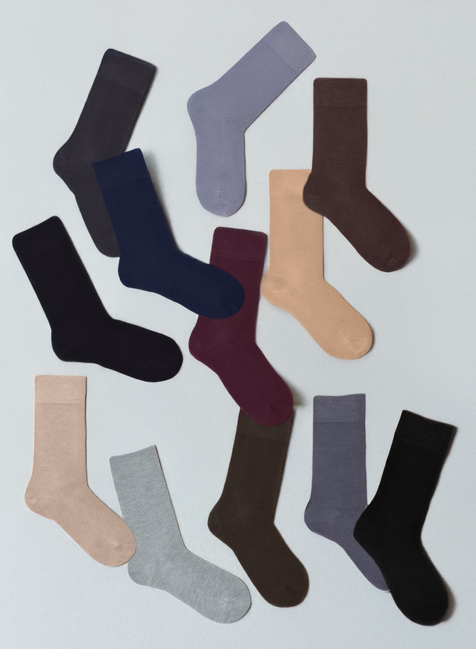 Collection of various colored socks on a light gray background