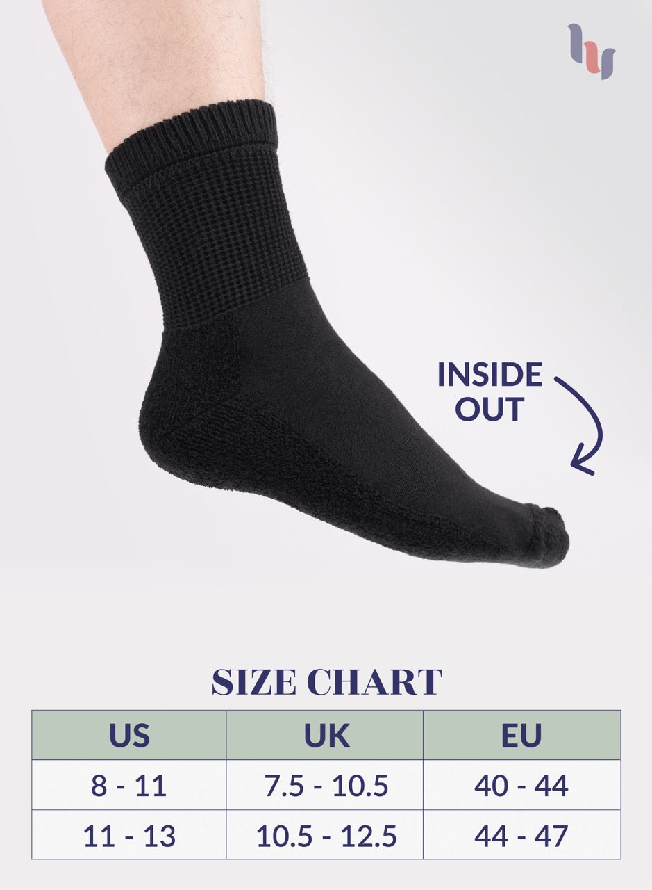 Black sock on a foot with size chart below on a light gray background