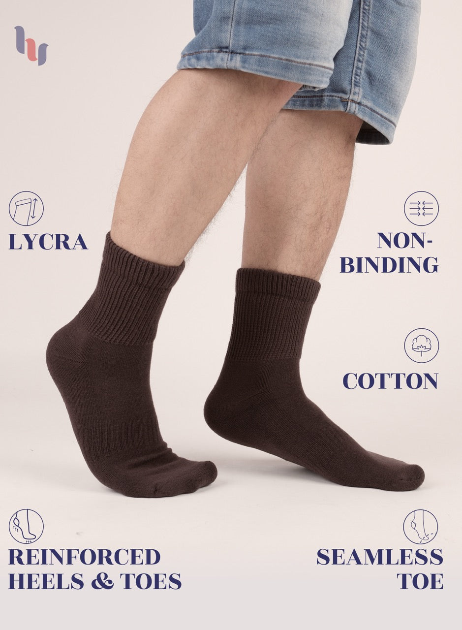 Brown socks worn with denim shorts on a light background, featuring LYCRA, non-binding, cotton, reinforced heels & toes, and seamless toe text.