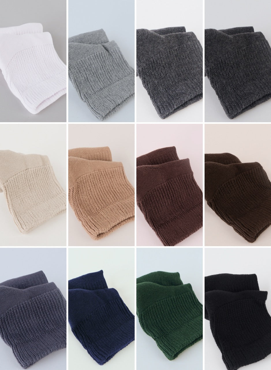 Collection of folded knitted scarves in various colors on a white background