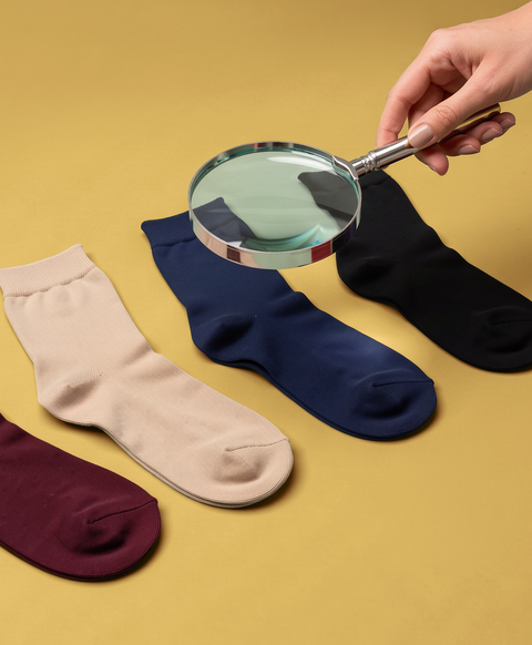 Hugh Ugoli Sock Finder featuring colorful crew socks and a magnifying glass to help shoppers find their perfect socks.