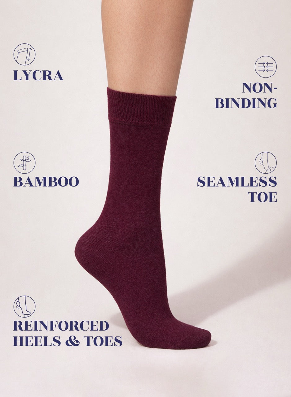 Burgundy sock on a white background with text highlighting features like Lycra, non-binding, bamboo, seamless toe, reinforced heels, and toes.