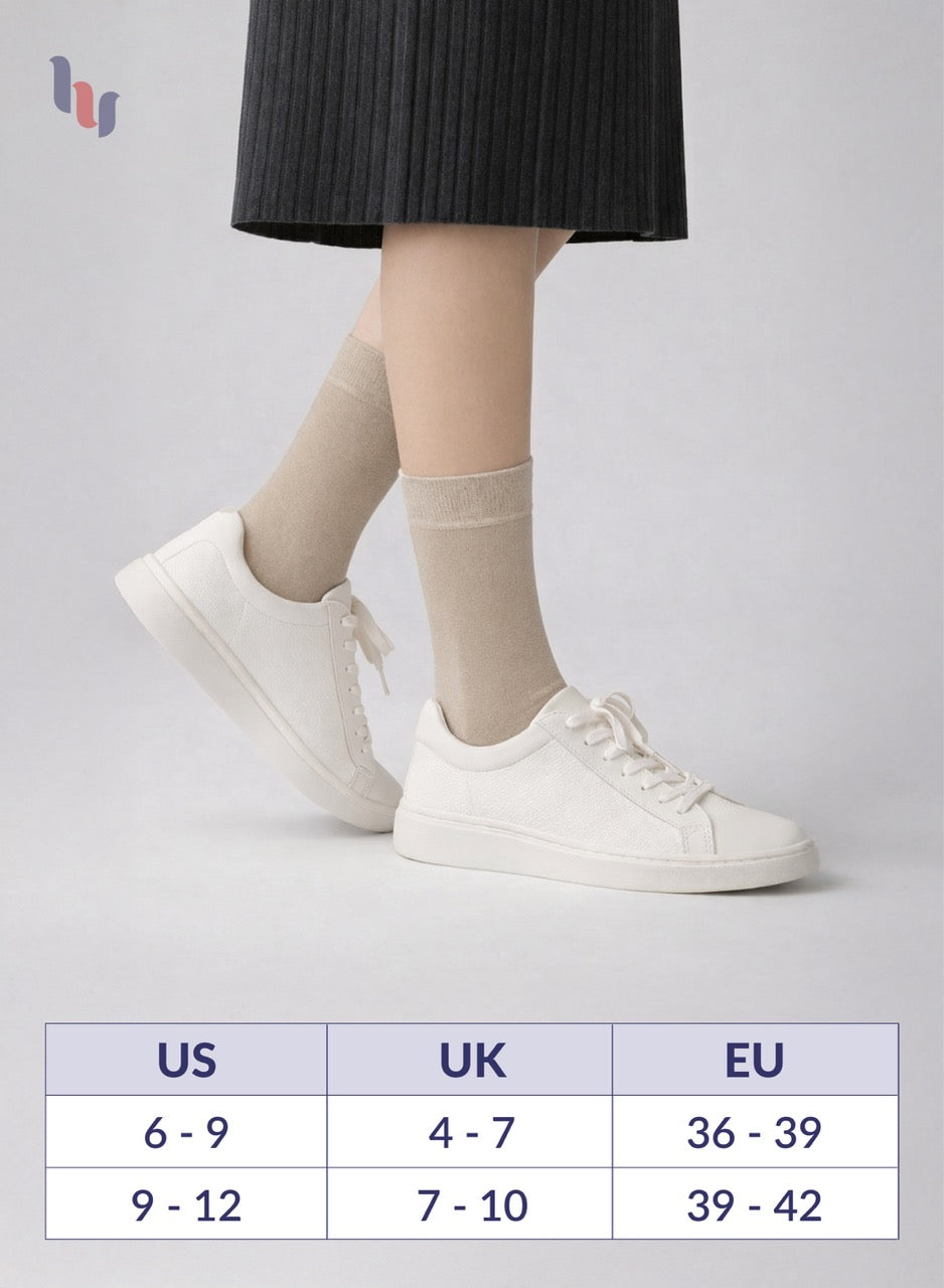 Person wearing light beige socks with white sneakers on a light gray background, with a size chart below.