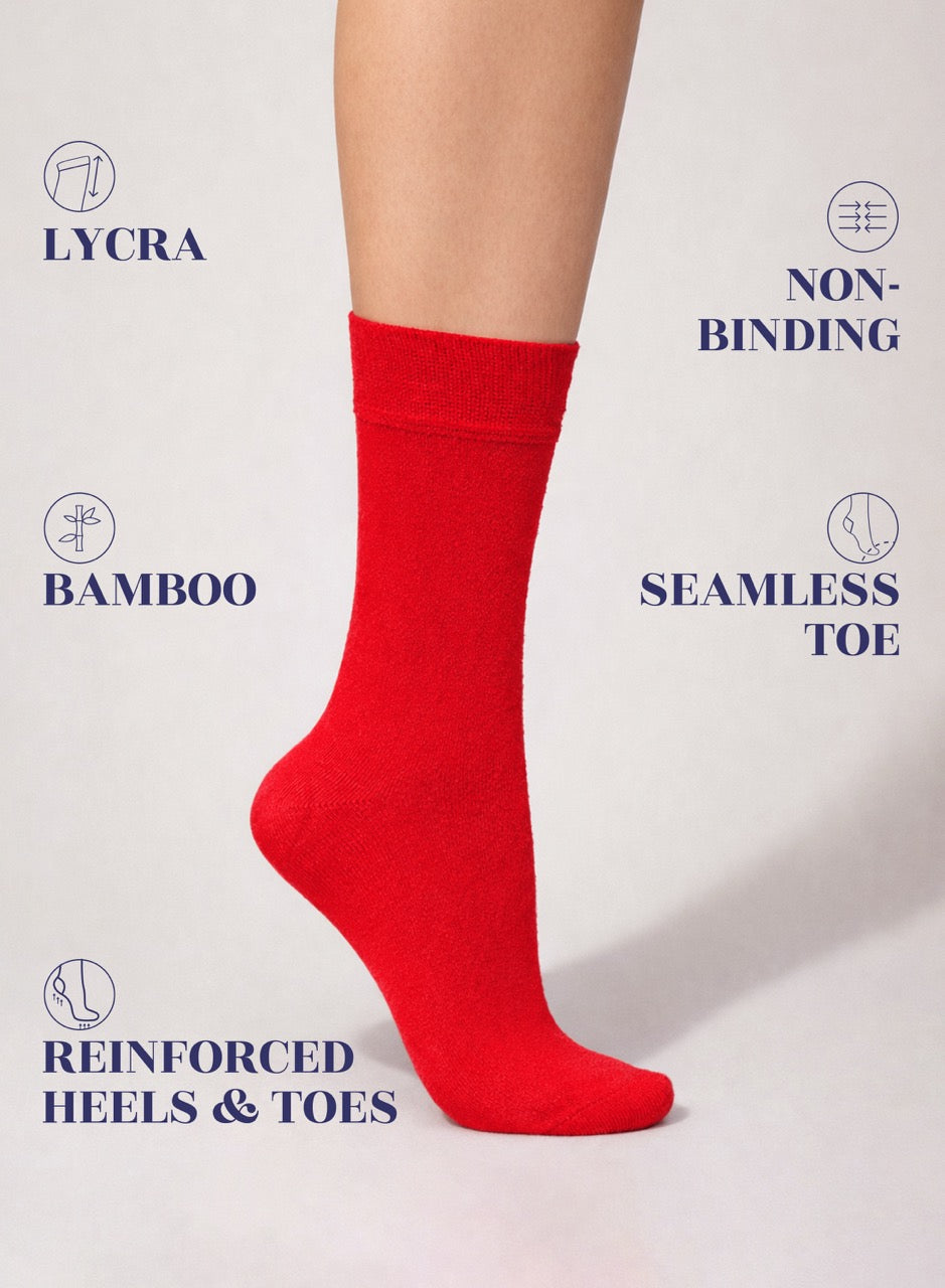 Red sock on a white background with text highlighting features like Lycra, Bamboo, Non-binding, Seamless Toe, and Reinforced Heels & Toes.