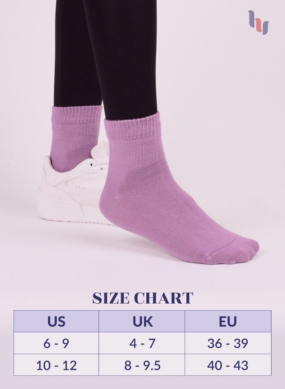 Lilac socks being worn with a size chart below on a light pink background