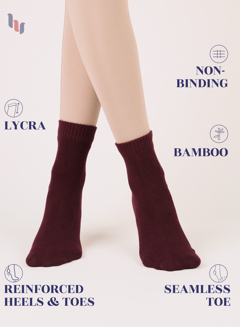 Burgundy socks worn by a person on a light background with product features highlighted.