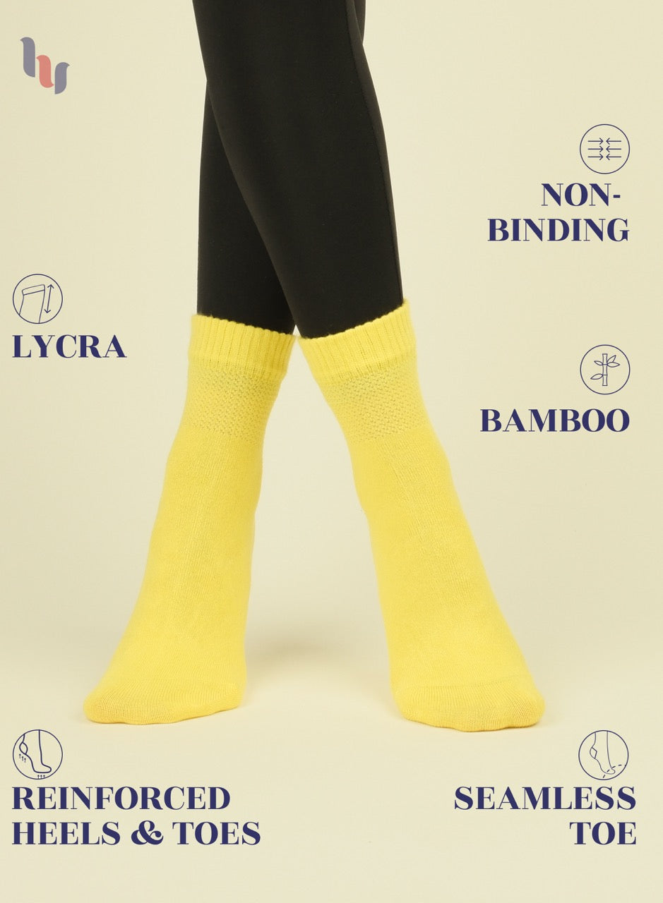 Yellow socks with black leggings on a beige background, featuring text about sock materials and features.