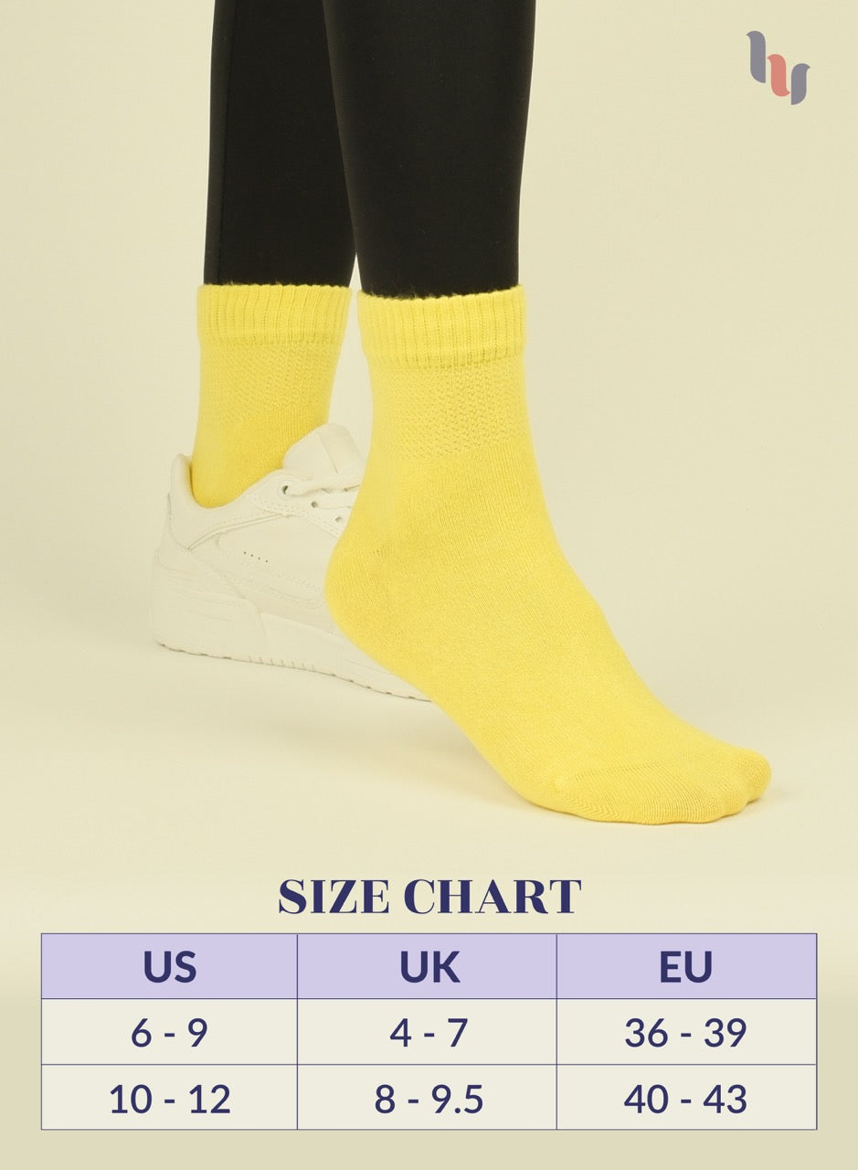 Yellow socks being worn with a size chart on a beige background