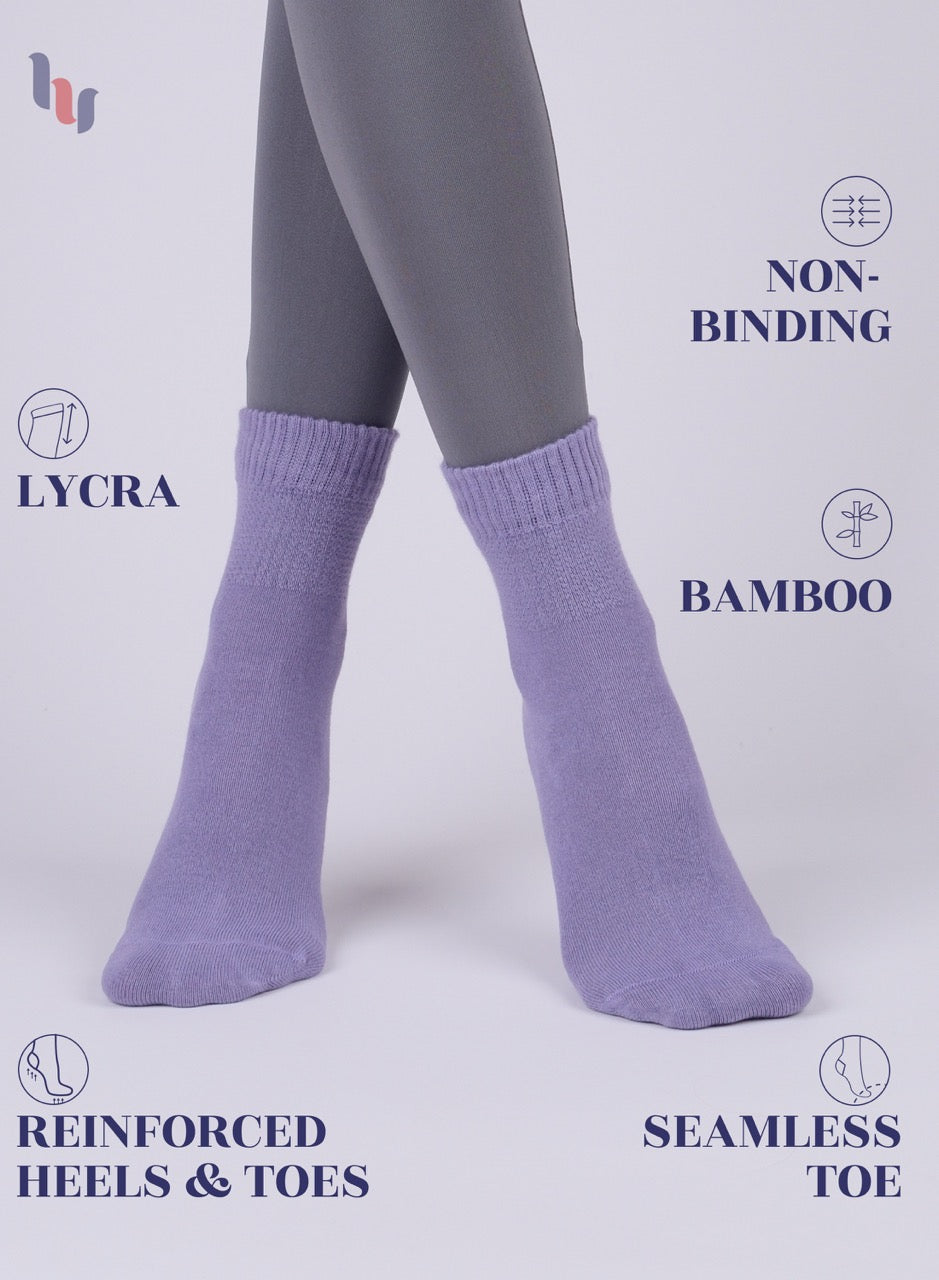 Aster Purple  socks worn with gray tights on a light gray background, featuring text about sock features.